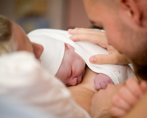 Newborn baby girl right after delivery, shallow focus